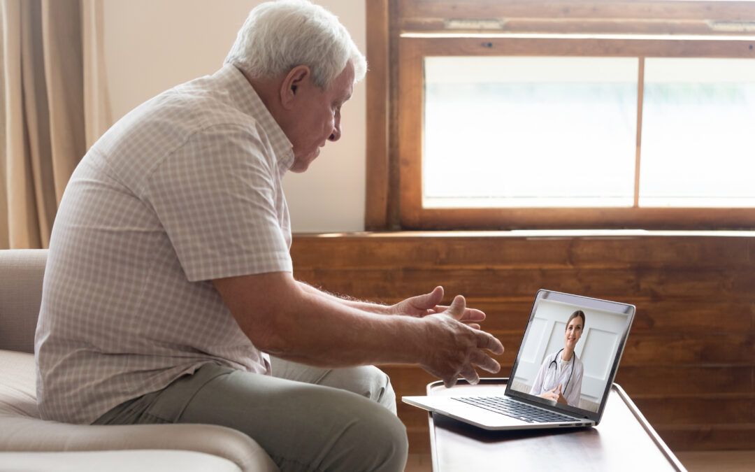 An elderly man is on a telemedicine call for his post-discharge follow-up appointment from a hospital.
